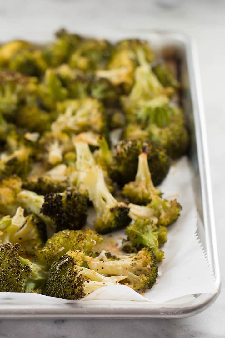 Close up of roasted broccoli on a baking sheet.