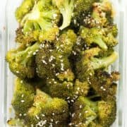 Sesame ginger roasted broccoli in a meal prep container. The broccoli meal prep was garnished with parmesan.