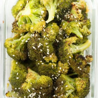 Sesame ginger roasted broccoli in a meal prep container. The broccoli meal prep was garnished with parmesan.