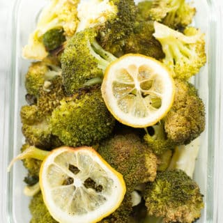 lemon roasted broccoli in a meal prep container. The broccoli meal prep was garnished with parmesan.