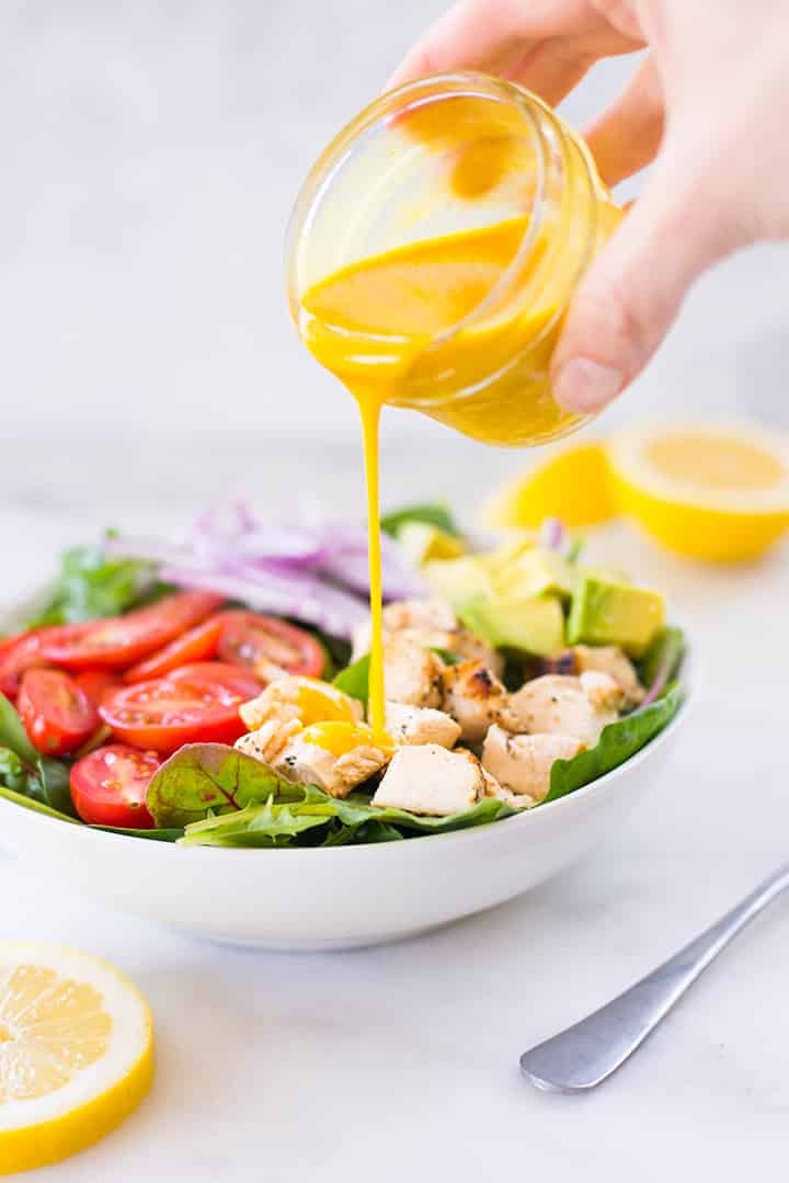 Drizzling Healthy Honey Mustard Dressing over salad.