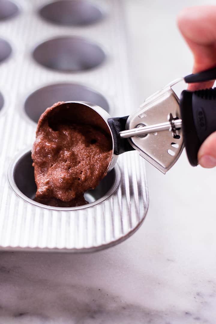 Filling muffin tin with chocolate batter.