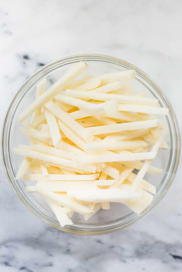 Top view of jicama slices in a mixing bowl.