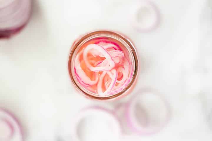 Top view of the pickled red onions in a mason jar.