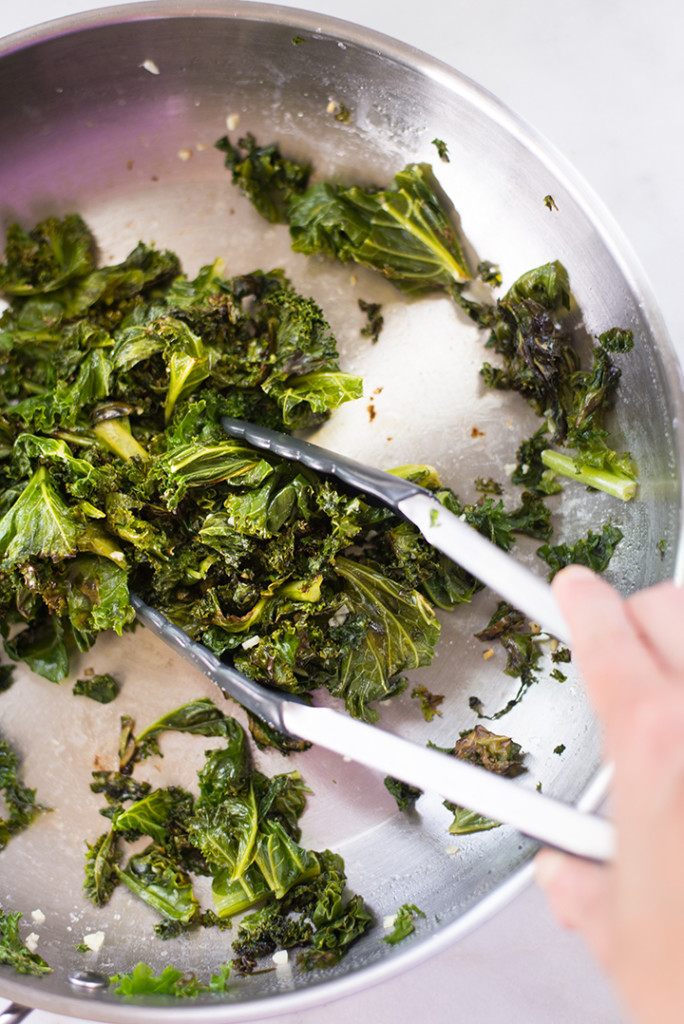 Hand tossing kale in a fry pan which is part of the lunch for the meal plan to reduce inflammation.