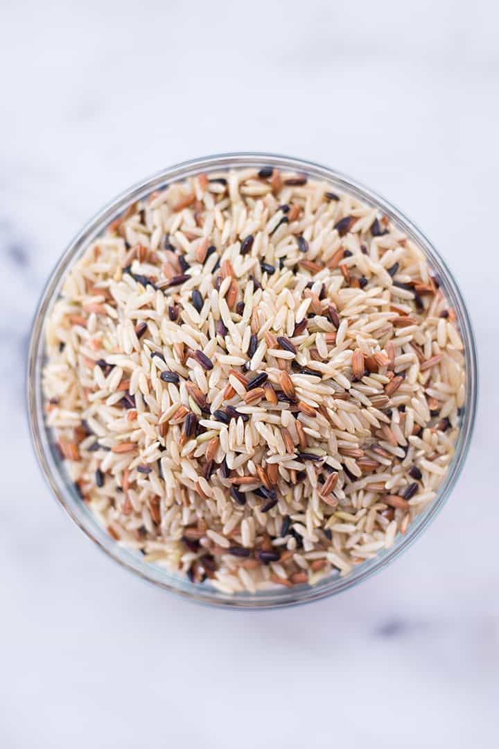 Overhead image of a glass bowl of wild rice which is an example of a whole grain that is an excellent vegan protein.