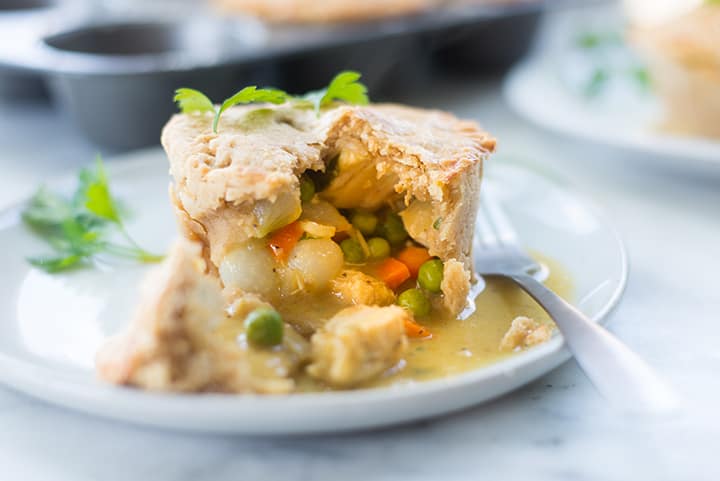 Side view of baked mini chicken freezer pot pie, which shows the buttery, flaky crust and the creamy, savory filling.