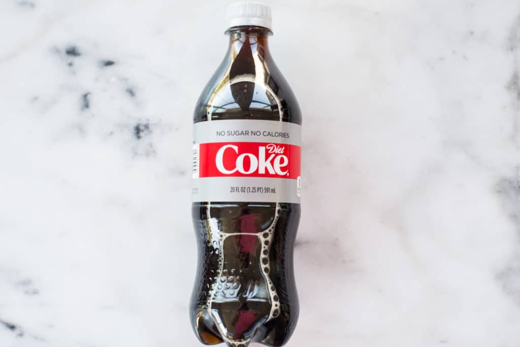 Overhead image of a bottle of diet soda which contains synthetic sugars like aspartame and sucralose.