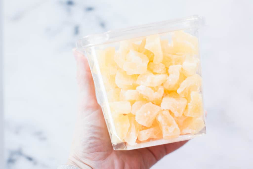 Image of a plastic container filled with dried pineapple, a sugary fake healthy food.