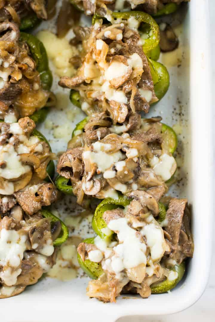 Close up overhead view of Keto Philly Cheesesteak Stuffed Peppers served in a white glass dish, and ready to eat
