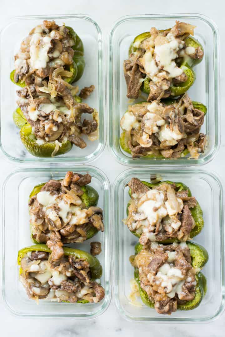 Overhead view of four Keto Philly Cheesesteak Stuffed Peppers Meal Preps in glass containers ready to store in the fridge as pre-prepared meals
