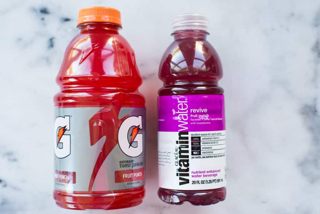 Image of two bottles of sports drinks, which have tons of food coloring as shown here in the red and purple liquids.