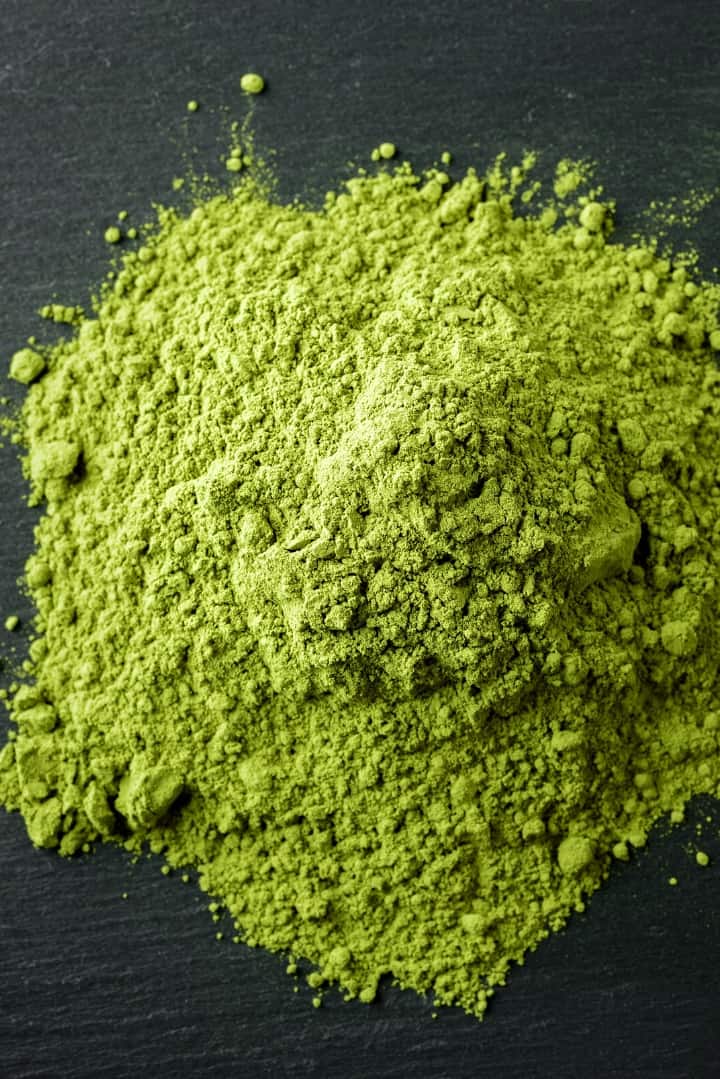 Overhead view of green tea in powdered form, ready to mix into a glass of green tea.