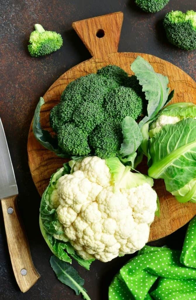 Close up overhead image of a head of broccoli and a head of cauliflower.