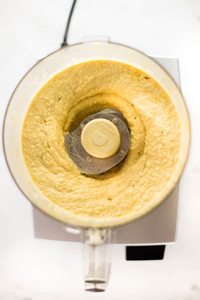 Overhead view of  creamy hummus in a food processor.