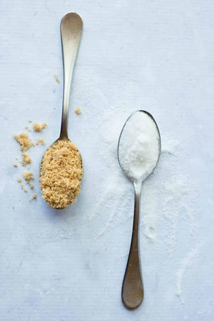 White and brown sugar in a spoon