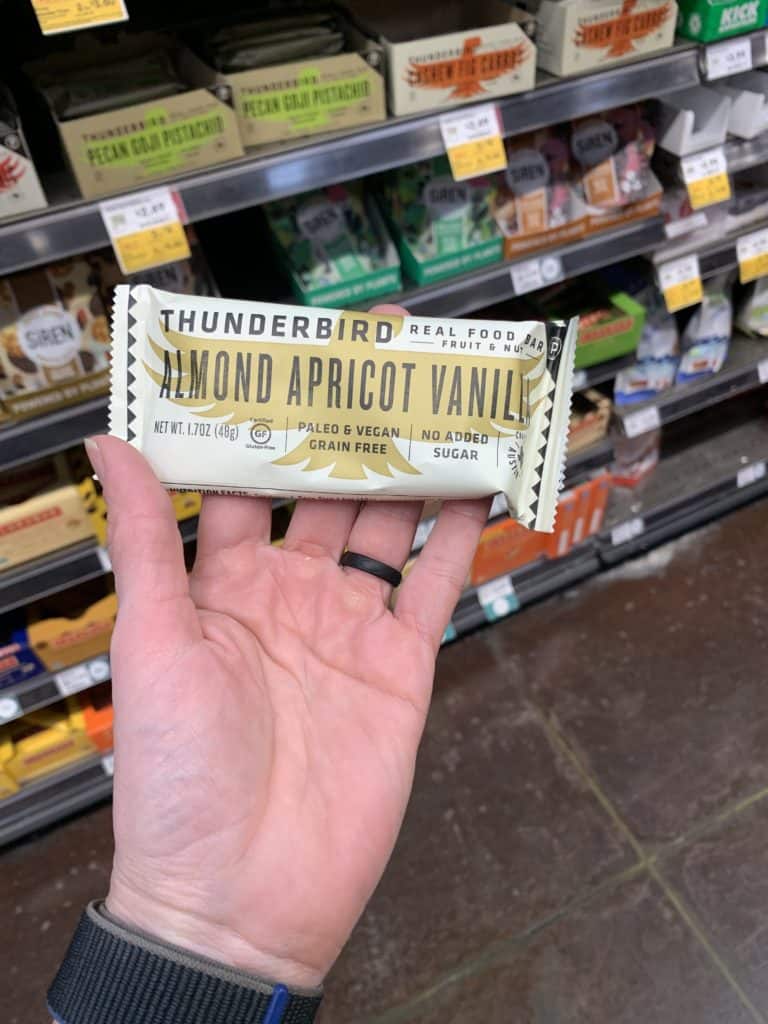 Close up image of a hand holding the Thunderbird Protein Bar.