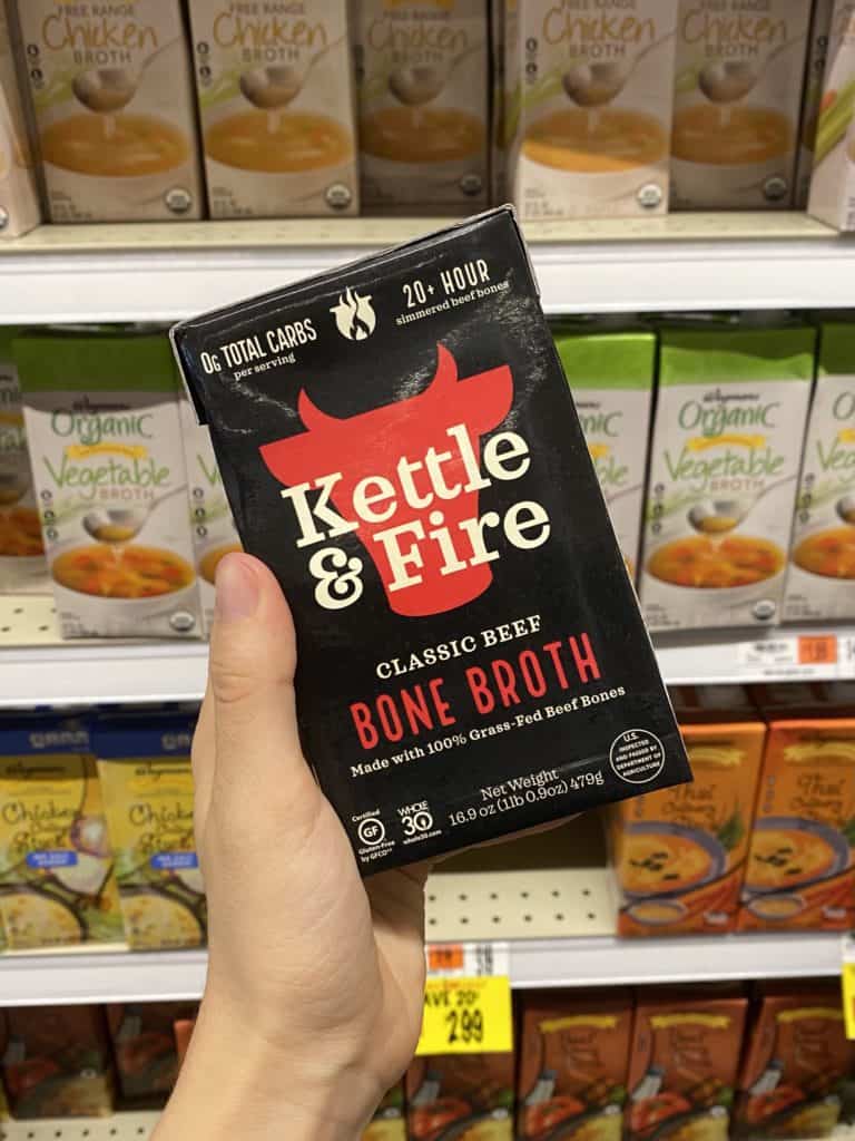 kettle & fire bone broth being held in a grocery store