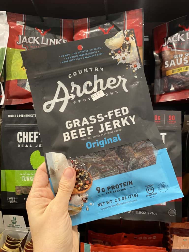 Country Archer grass-fed beef jerky package being held up in the store