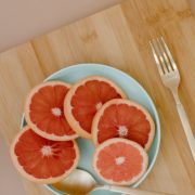 5 slices of fresh grapefruit on a blue plate