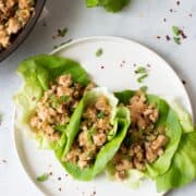 Top down view of 3 chicken lettuce wraps on a plate.