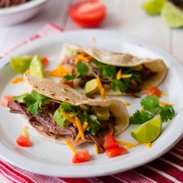 Crock Pot Shredded Beef Tacos side view on a plate