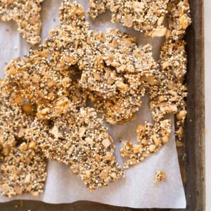 Quinoa Peanut Brittle broken on a sheet pan