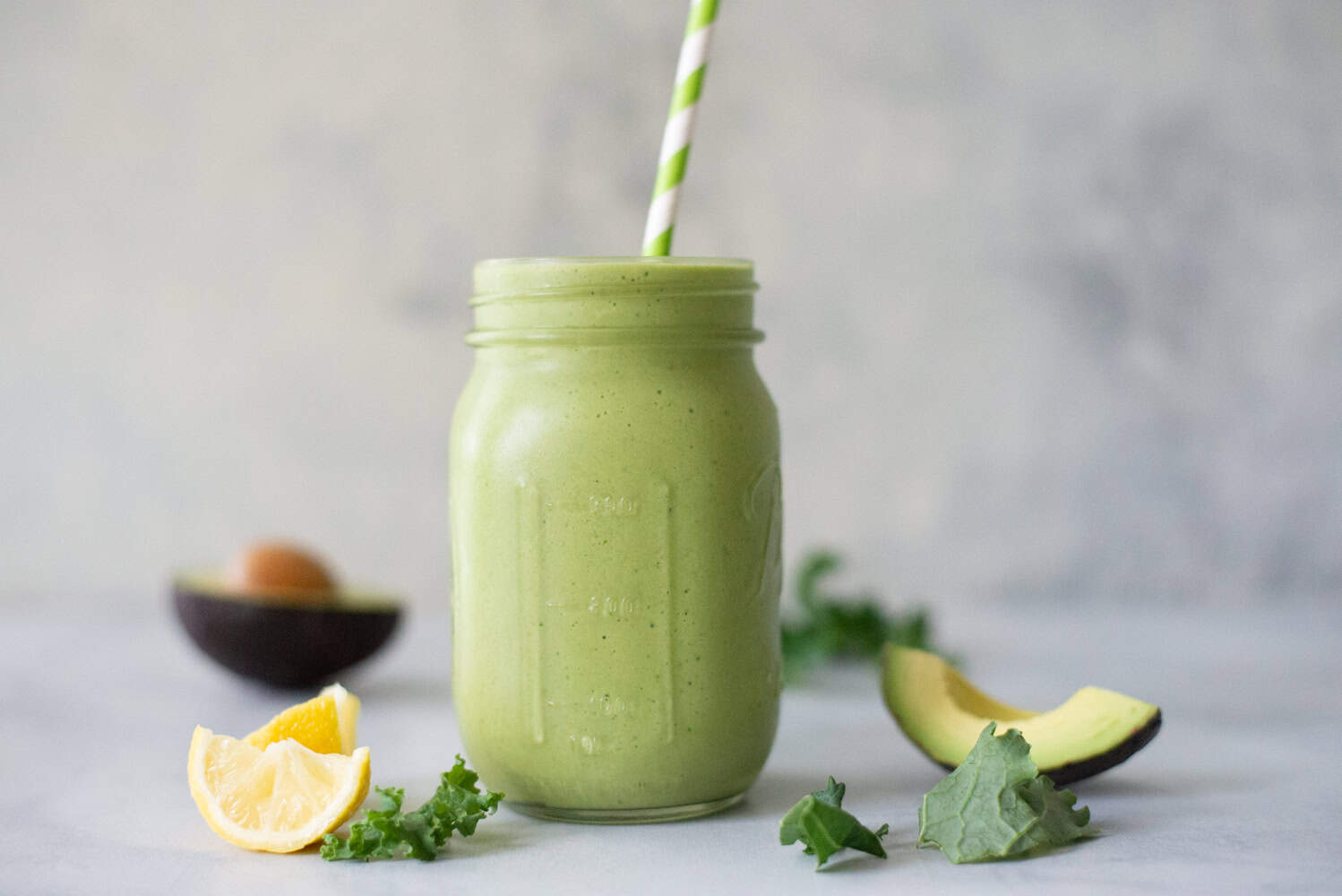 horizontal image side view of plated avocado kale protein smoothie
